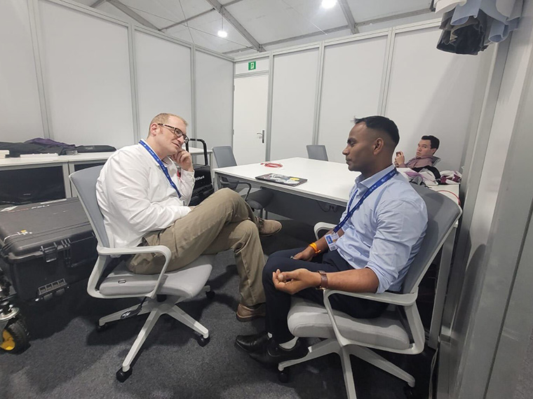 Peter Prengaman (on left), AP’s global climate and environment news director, and Press Trust of India reporter Gaurav Saini talk about various enterprise stories Saini was developing at COP28. (Photo by Sibi Arasu)